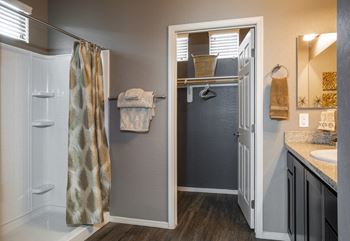 Bathrooms with dual sinks, wood plank floors, walk-in showers